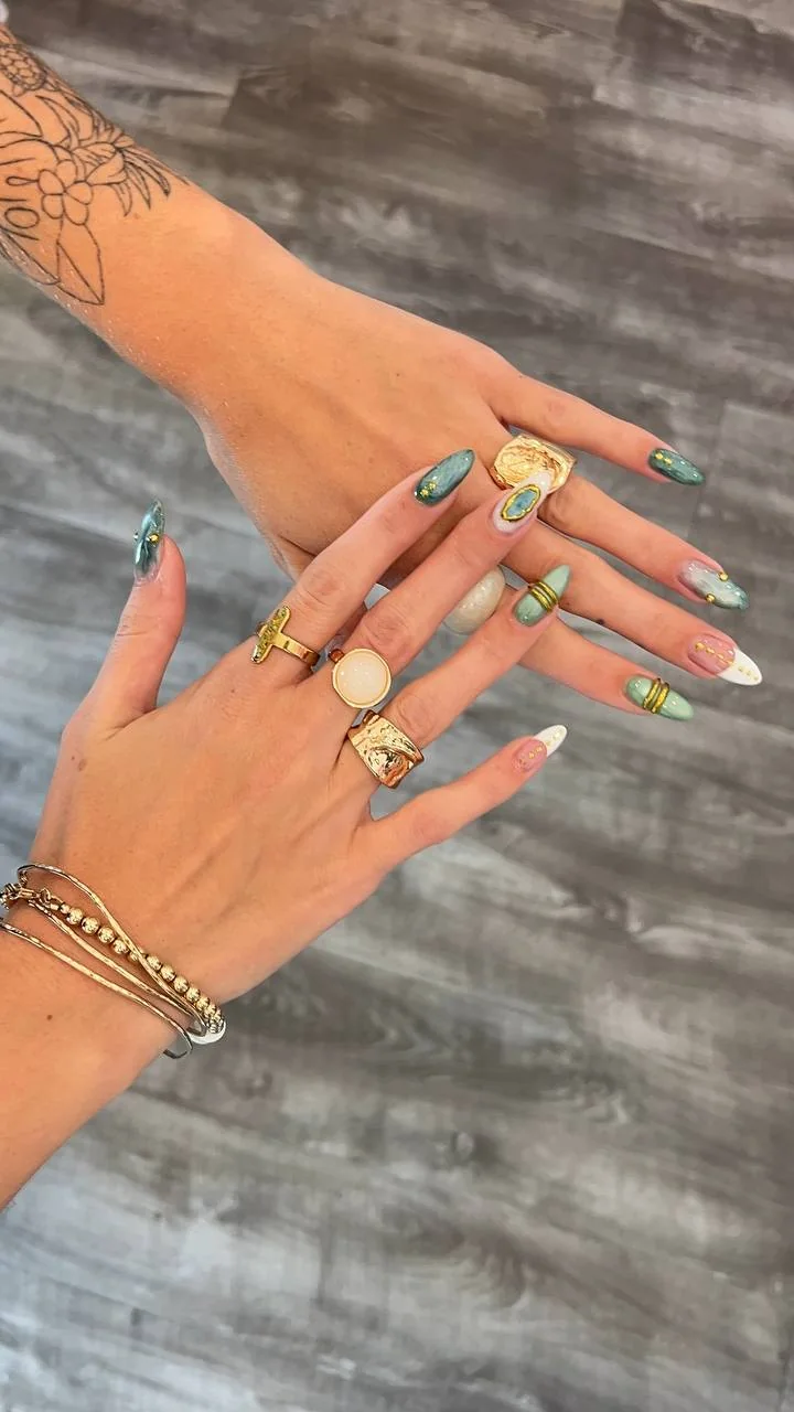 Long almond nail art in green, nude and white with gold details